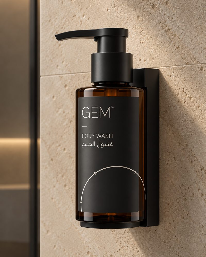 Concept image: GEM body wash bottle held in a black wall-mounted bracket on a stone wall.
